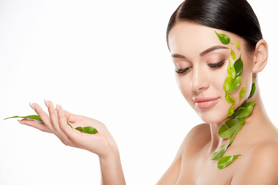 Mlađa žena sa listovima po licu ramenu i ruci