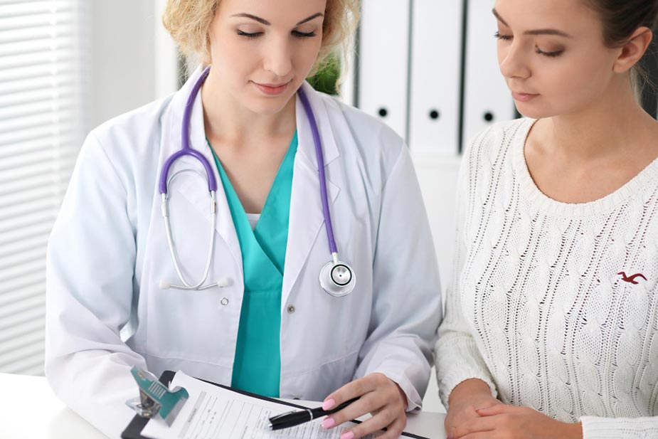 Lekarka koja pregleda dokumentaciju sa pacijentkinjom. Prevencija za žene.