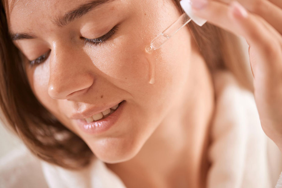 Žena nanosi serum sa antioksidansima protiv oštećenja kože izazvanih okolinom.