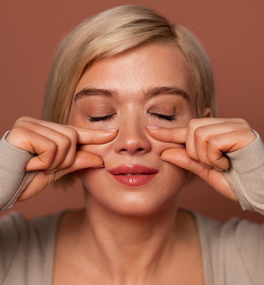 Žena izvodi vežbe za lice za poboljšanje cirkulacije