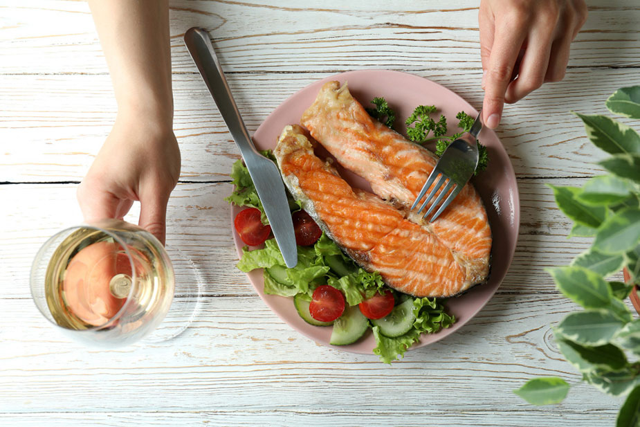 Tanjir sa sveže ispečenim komadom lososa okruženog salatom