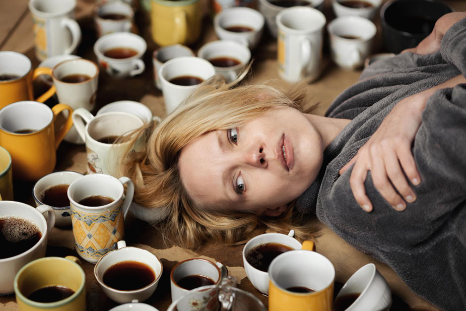Žena okružena šoljicama kafe