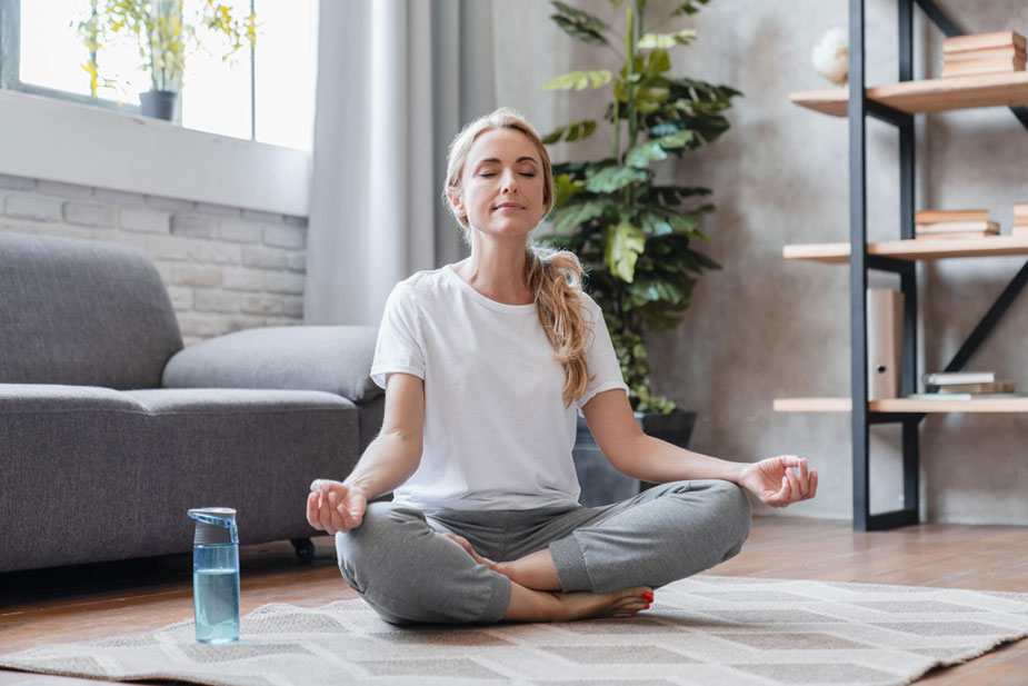Žena sedi u tihoj meditaciji, fokusirajući se na disanje i unutrašnji mir.
