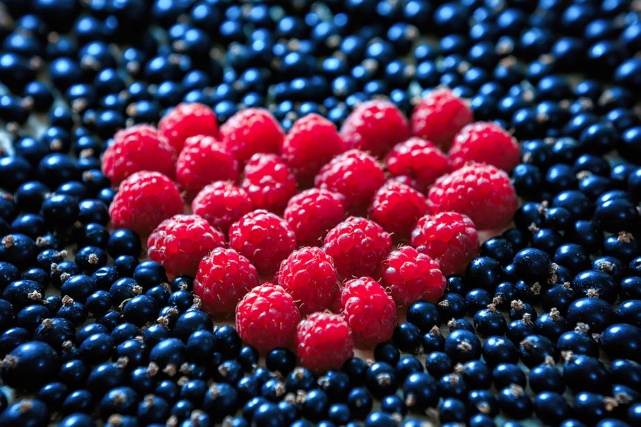 Simbolički prikaz srca napravljen od malina i borovnica