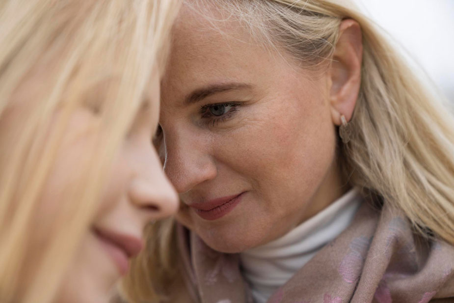 Dve žene u četrdesetim dodiruju se glavama u znak podrške.