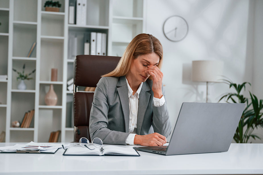 Umorna žena sa glavoboljom ispred računara – posledice stresa i mentalnog zamora