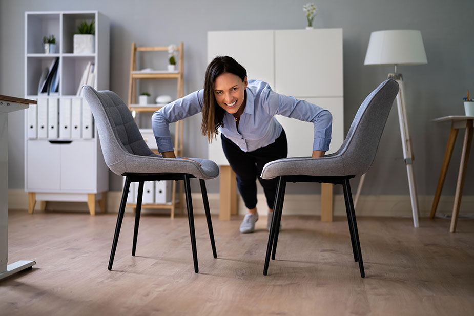 Žena pravi sklekove koristeći dve stolice