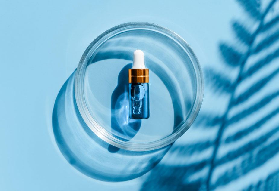 Plavi serum u staklenoj činiji — simbol potentnih aktivnih sastojaka poput AHA, BHA i retinola.