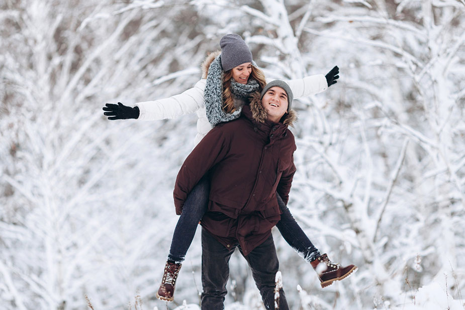 Par uživa u zabavnom trenutku tokom šetnje po snegu.
