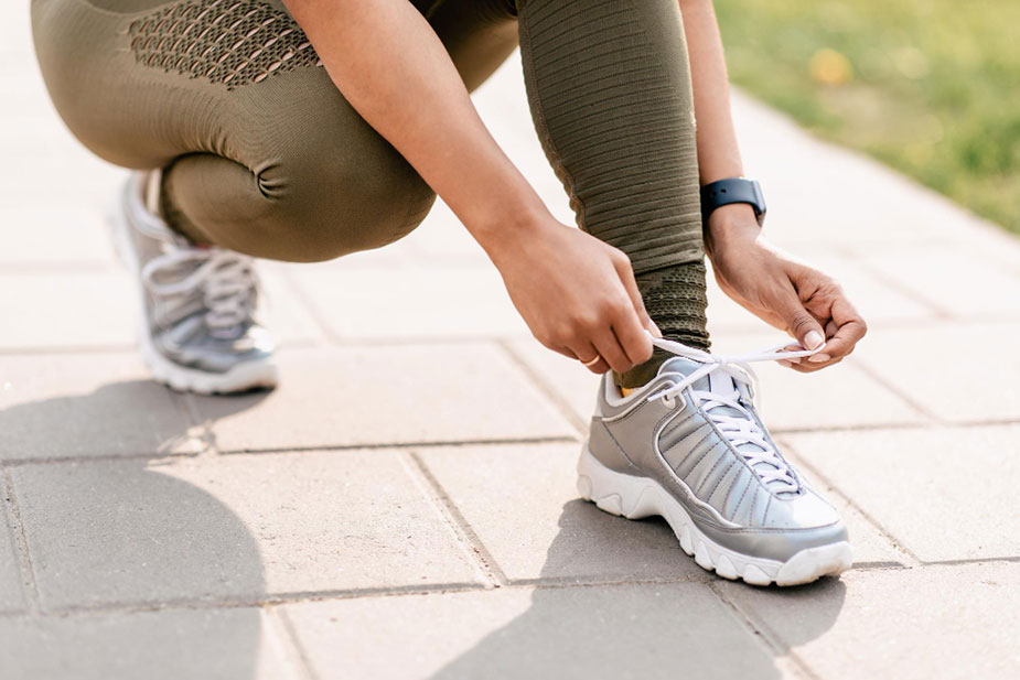 Krupni kadar vezivanja pertli na patikama pre šetnje.